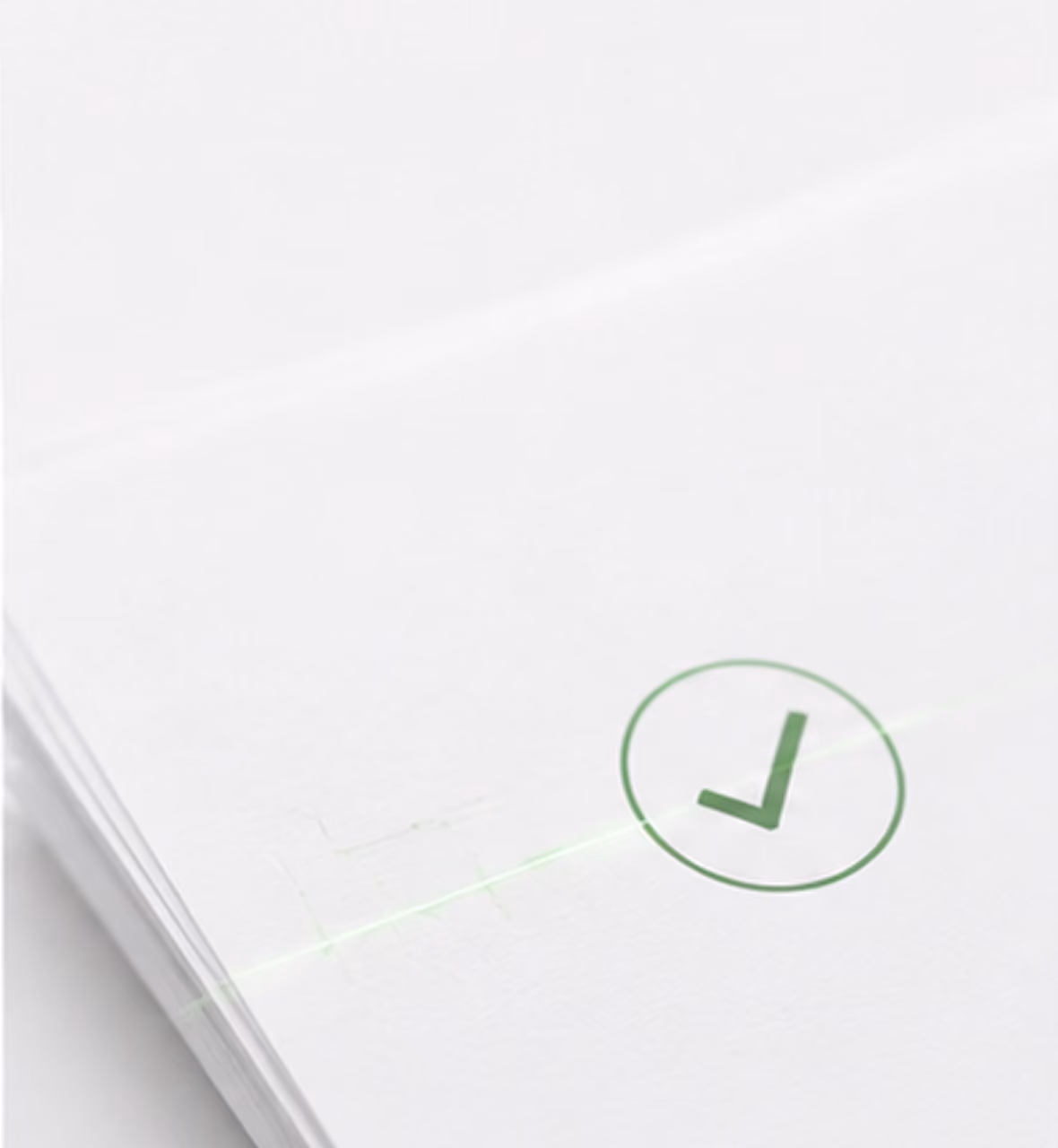 Green checkmark inside a circle printed on a stack of white paper sheets.